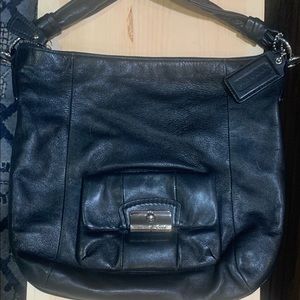 Womans black coach shoulder bag with front pocket